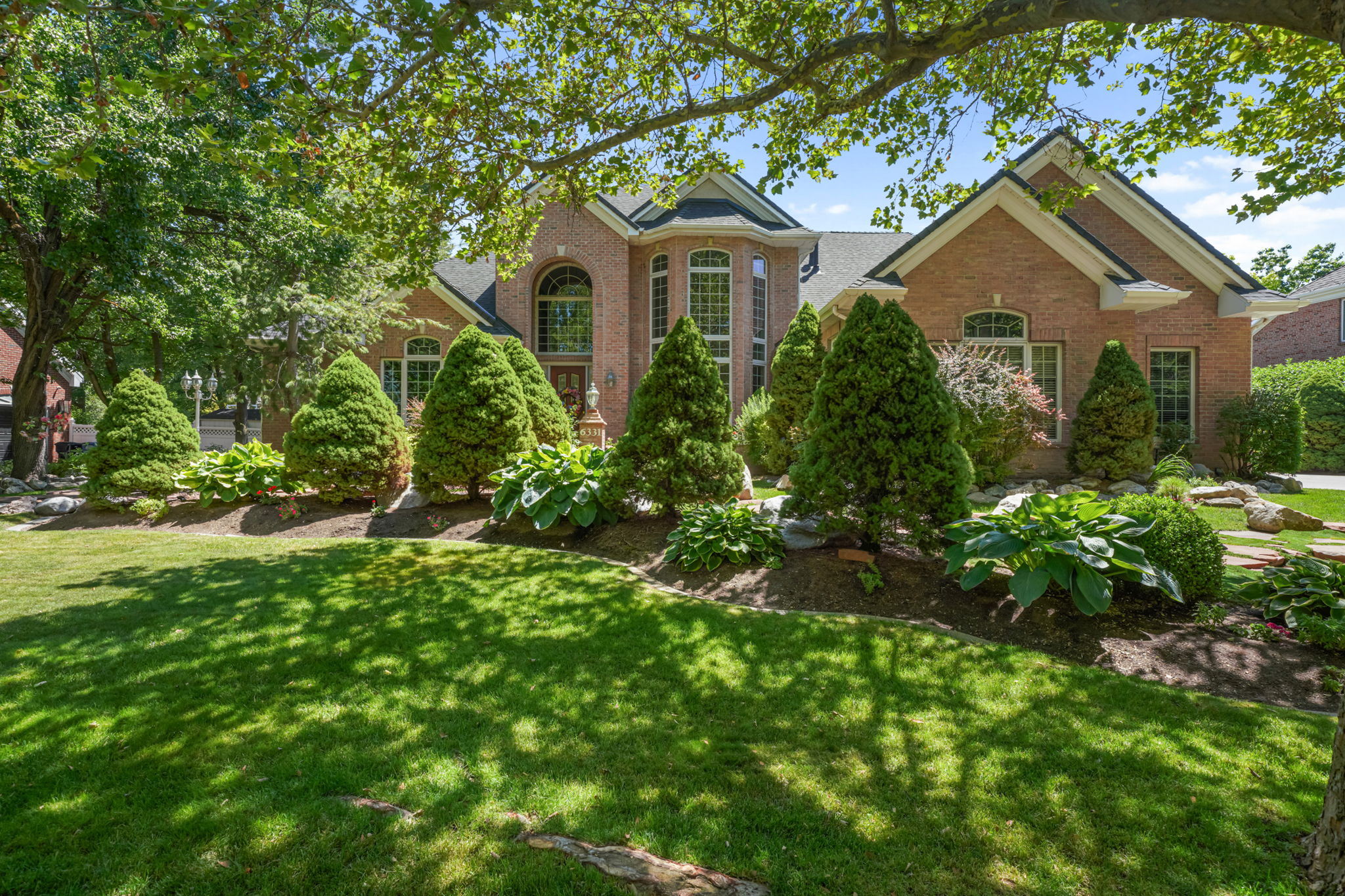 Traditional-style house with a front yard and brick siding