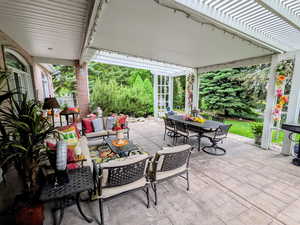 View of patio featuring outdoor dining space, a pergola, and an outdoor hangout area