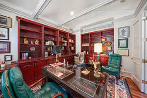 Home office featuring wood finished floors, lofted ceiling, and ornamental molding
