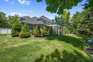 View of front of property with a pergola, brick siding, and roof with shingles