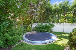 Fenced backyard with a trampoline