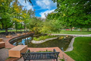 View of home's community featuring a garden pond and a lawn