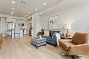 Living area featuring recessed lighting, light wood-style floors, and baseboards