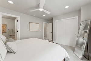 Primary bedroom featuring a closet, recessed lighting, a ceiling fan, baseboards, and light carpet