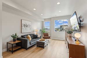 Living room featuring light wood-type flooring, recessed lighting, and baseboards