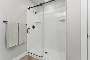 Primary Bathroom with a large walk-in shower and baseboards