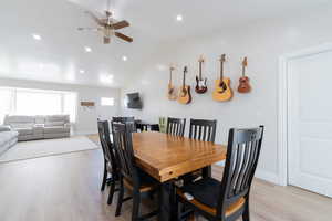 Dining area with a ceiling fan, light wood finished floors, lofted ceiling, recessed lighting, and baseboards