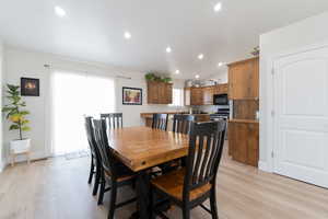 Dining area with light wood-style flooring, recessed lighting, lofted ceiling, and baseboards