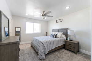 Bedroom with light carpet, baseboards, and ceiling fan