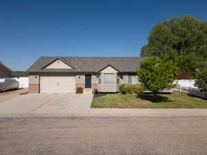 View of front of home featuring brick siding, a garage, driveway, and roof with shingles