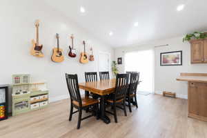 Dining area with light wood-style floors, recessed lighting, baseboards, and vaulted ceiling