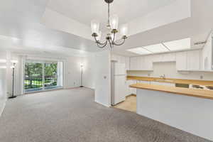 Kitchen with freestanding refrigerator, a sink, light colored carpet, open floor plan, and butcher block counters