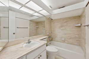 Full bathroom featuring toilet, shower / bath combination, vanity, and tile patterned flooring