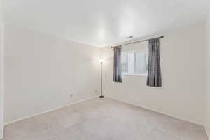 Spare room featuring carpet and baseboards