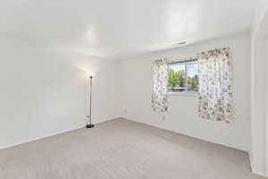 Empty room with light carpet and baseboards
