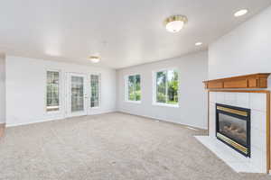 Unfurnished family room featuring a fireplace, baseboards, light colored carpet, and recessed lighting