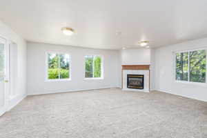 Family room featuring light colored carpet, a fireplace, and baseboards
