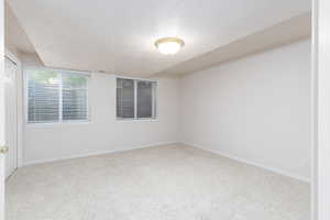 Carpeted bedroom with a textured ceiling and baseboards