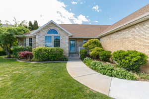 Property entrance with new roof within last 3 years, a yard, and brick siding