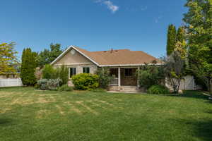 Rear view of property featuring a porch and brick siding and fully fenced yard