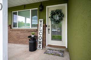 Doorway to property with brick siding and stucco siding