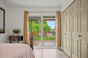 Bedroom with access to outside, light wood-style flooring, and a closet