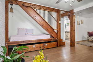 Stairway featuring a ceiling fan, hardwood / wood-style floors, and baseboards