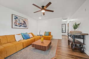 Living room featuring wood finished floors, a ceiling fan, and baseboards