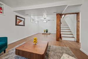 Living room featuring baseboards, stairs, and wood finished floors