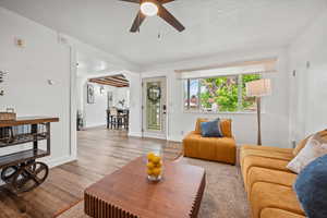 Living area featuring a ceiling fan, wood finished floors, baseboards, and arched walkways