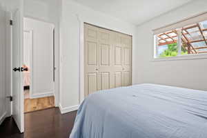 Bedroom featuring dark wood finished floors, a closet, and baseboards