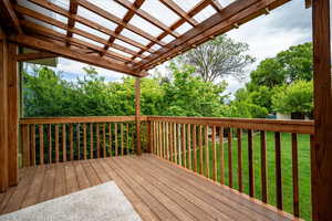 Wooden terrace with a pergola and a yard