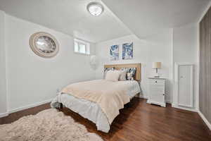 Bedroom featuring baseboards, wood finished floors, and a textured ceiling
