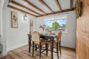Dining room featuring beam ceiling, wood finished floors, and baseboards