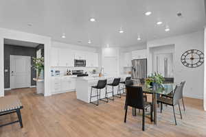Dining area featuring baseboards, light wood-style flooring, and recessed lighting