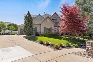 View of front of house featuring stucco siding, stone siding, a front lawn, driveway, RV parking and 3 car garage
