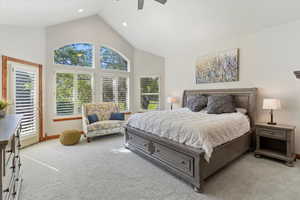 Primary Bedroom with views, light colored carpet, high vaulted ceiling, ceiling fan, and recessed lighting