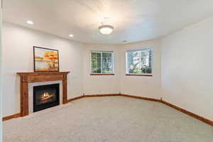 ADU with carpet, a tiled fireplace, baseboards, and recessed lighting