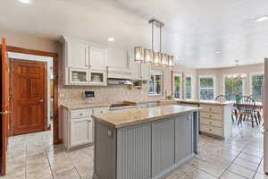 Kitchen featuring an island, a chandelier, healthy amount of natural light, a center island, and a textured ceiling