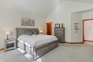 Bedroom with light carpet, and high vaulted ceiling