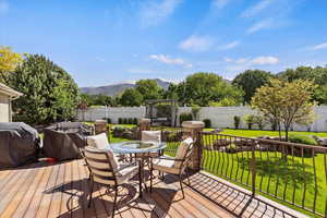 Deck featuring outdoor dining area, grilling area, and a mountain view