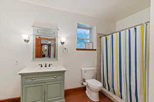 ADU Full bath with laminate floors, toilet, vanity, a shower/tub