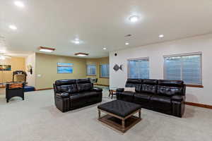 Carpeted living area featuring baseboards, recessed lighting, and ceiling fan