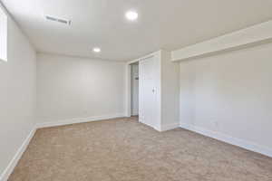 Basement with carpet flooring, a textured ceiling, baseboards, and recessed lighting