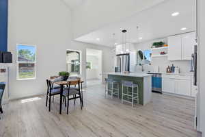 Kitchen with stainless steel appliances, healthy amount of natural light, a kitchen island, open shelves, and recessed lighting