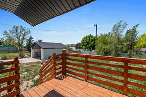 Deck featuring an outdoor structure and driveway