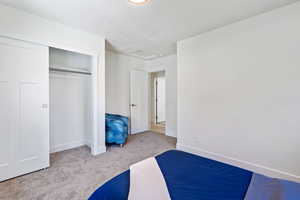 Unfurnished bedroom with carpet, baseboards, a closet, and a textured ceiling