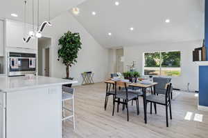 Dining space featuring recessed lighting, light wood-style floors, baseboards, and high vaulted ceiling