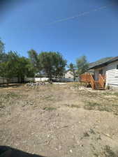 View of yard with a wooden deck and stairway