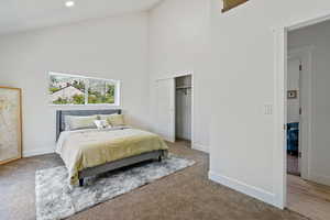 Bedroom with high vaulted ceiling, carpet flooring, baseboards, a closet, and recessed lighting